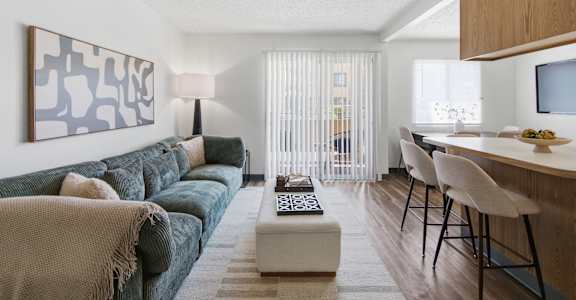 A living room with a couch, a coffee table, and a painting on the wall.