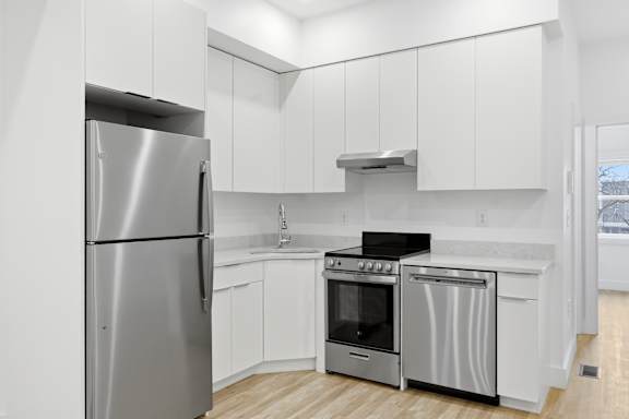 A modern kitchen with a stainless steel refrigerator and oven.