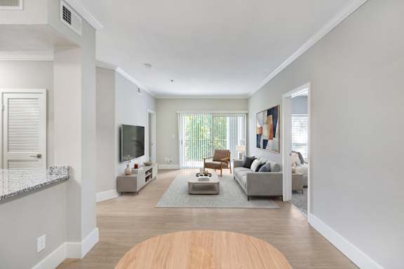 A modern living room with a wooden floor and a grey couch.