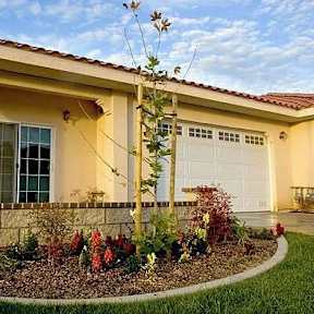A house with a well-maintained garden in front.