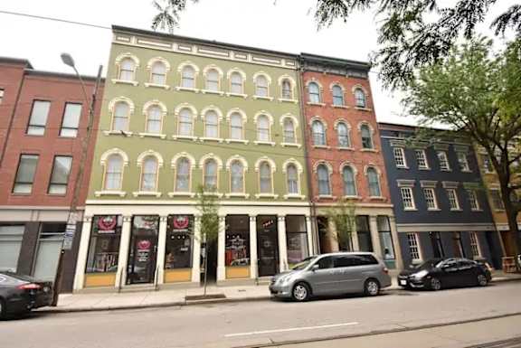 A row of three-story buildings with a row of windows on the second floor.