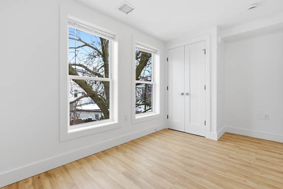 A room with a window showing a tree outside.