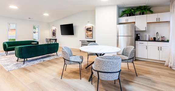 A modern living room with a green sofa and grey chairs.
