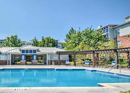 a swimming pool with a building and trees in the background at The Atlantic Station, Ft Worth, TX, 76131
