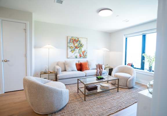 a living room with a couch and two chairs and a coffee table