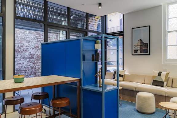 a living room with a blue room divider and a table with chairs