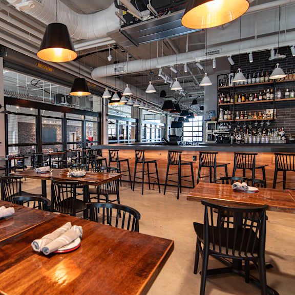 the interior of a restaurant with tables and chairs and a bar