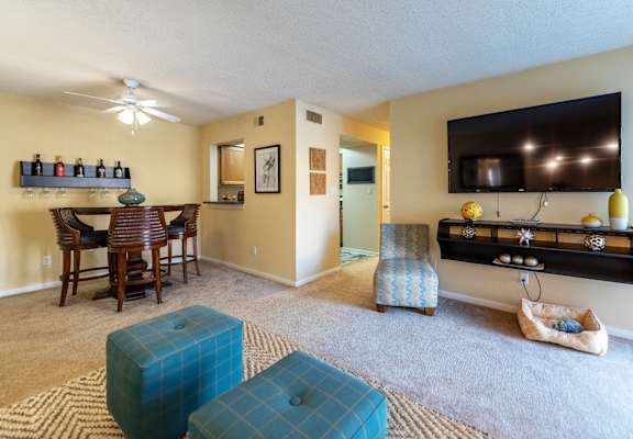 a living room and dining room with a tv and a table and chairs