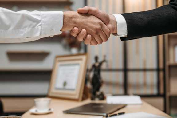 two people shaking hands in an office