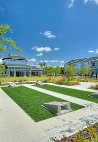 a park with benches and grass in front of a building