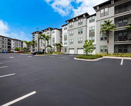 an empty parking lot in front of a large apartment building