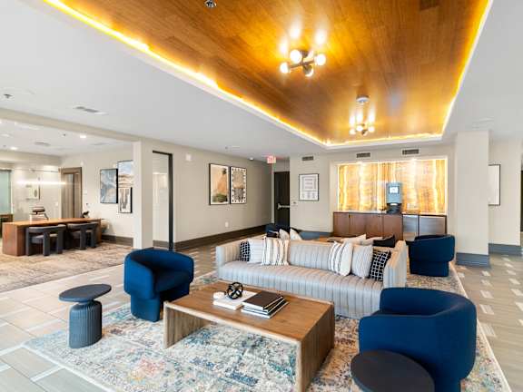 A large room with a long white couch and a wooden ceiling.
