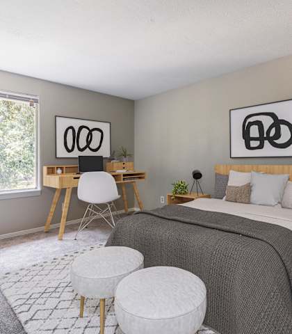 A bedroom with a bed, desk, and chair.
