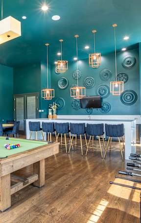 a game room with a pool table and a bar