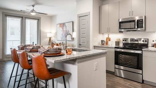 A modern kitchen with a dining table set for four.