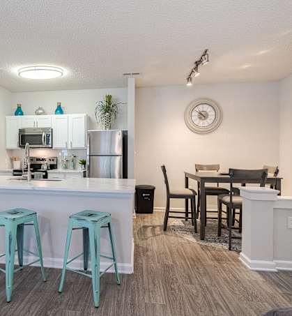 A kitchen with a bar area and a dining table.
