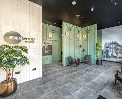 A lobby with a green wall and a sign that says Edenwood House.