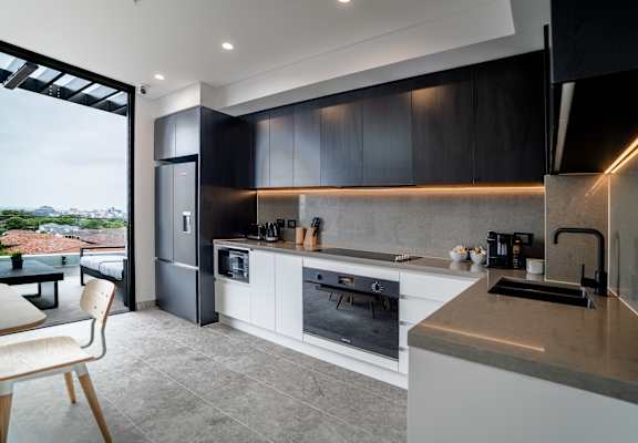 a kitchen with black and white cabinets and a large window