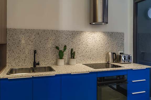 a kitchen with blue cabinets and a counter top and a sink