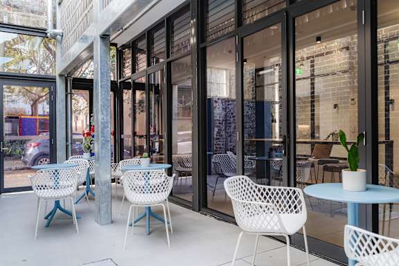 a patio with chairs and tables and glass doors