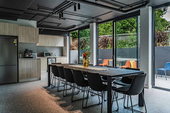 a dining room with a table and chairs and a kitchen with glass doors