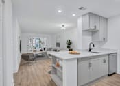 Thumbnail 2 of 25 - A modern kitchen with white cabinets and a large island.