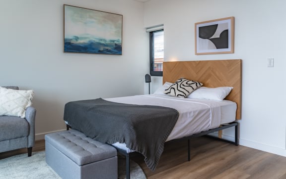 a bedroom with a bed and a chair and a window