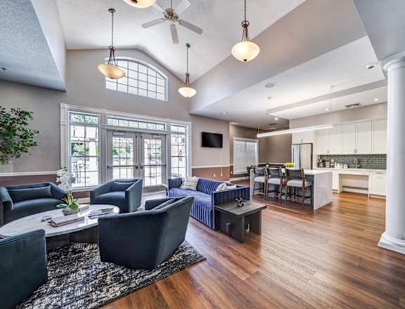 A living room with a dark blue sofa and a wooden floor.