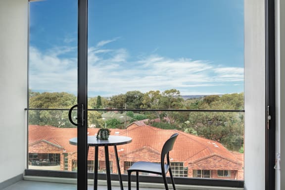 a small table in front of a window with a view of a house