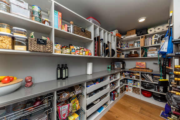 A well-stocked pantry with shelves filled with food and kitchen supplies.