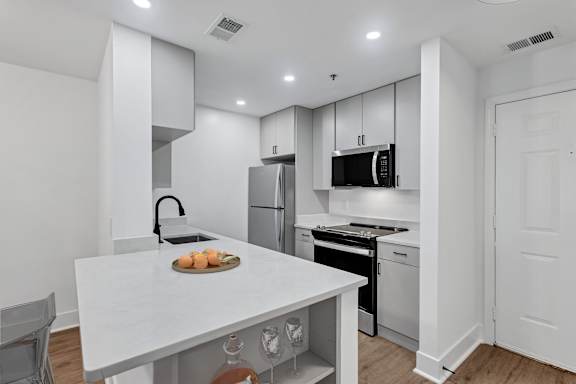 A modern kitchen with white cabinets and appliances.