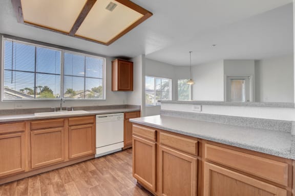 a kitchen with white countertops and wood floors at Aspen Peak, Henderson, Nevada