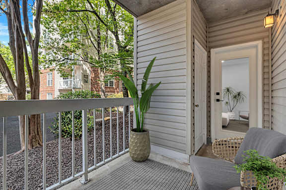A balcony with a chair and a potted plant.