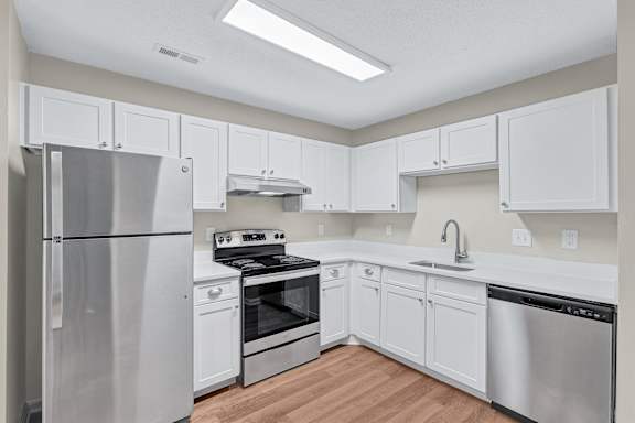 A kitchen with white cabinets and stainless steel appliances.