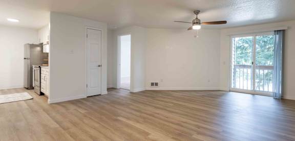 an empty living room with a ceiling fan