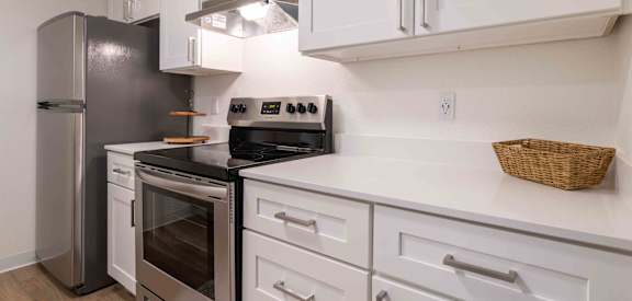 a kitchen with white cabinets and stainless steel appliances