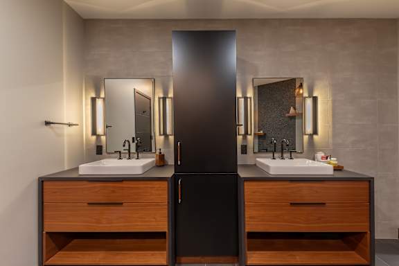 a bathroom with two sinks and two mirrors