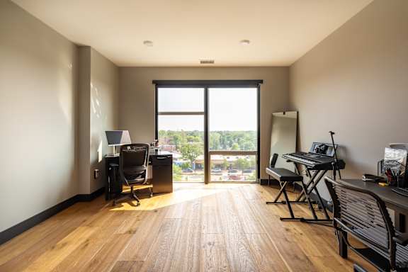 A room with a desk, chair, and laptop.