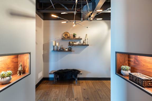 a living room with a table and shelves on the wall