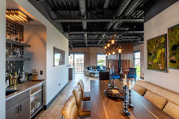 the kitchen and living room of a house with a large wooden table and chairs