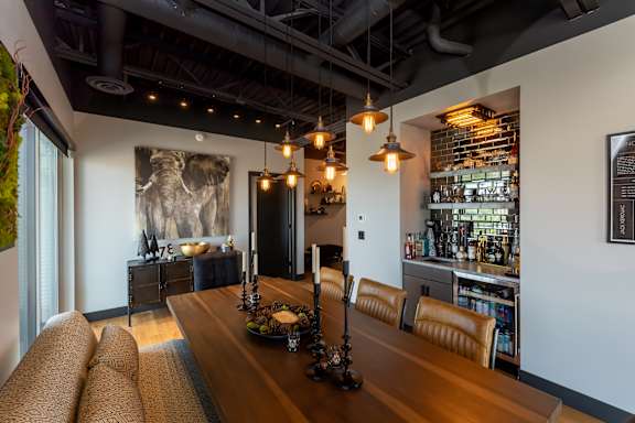 a dining room with a wooden table and chairs and a bar