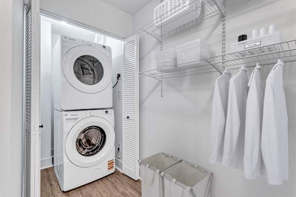 A white laundry room with a washer and dryer stacked on top of each other.