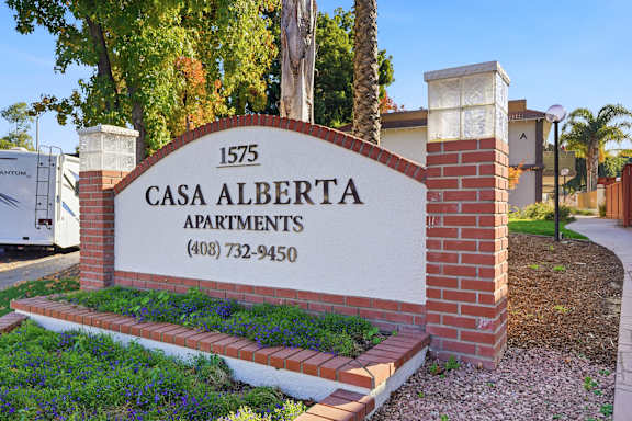 A sign for Casa Alberta Apartments with a phone number on it.