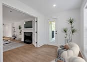Thumbnail 4 of 25 - A modern living room with a fireplace and a television.