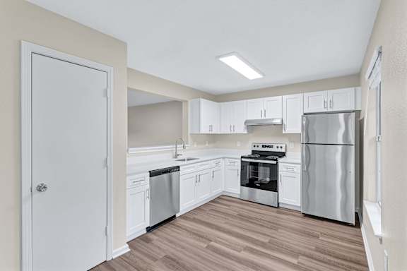 A kitchen with white cabinets and stainless steel appliances.