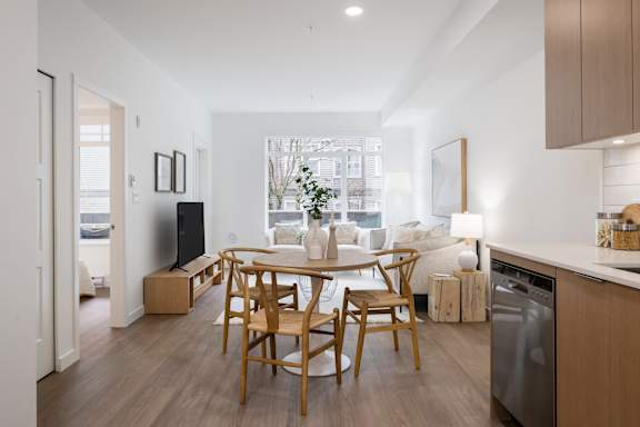 A modern kitchen with a dining table and chairs.