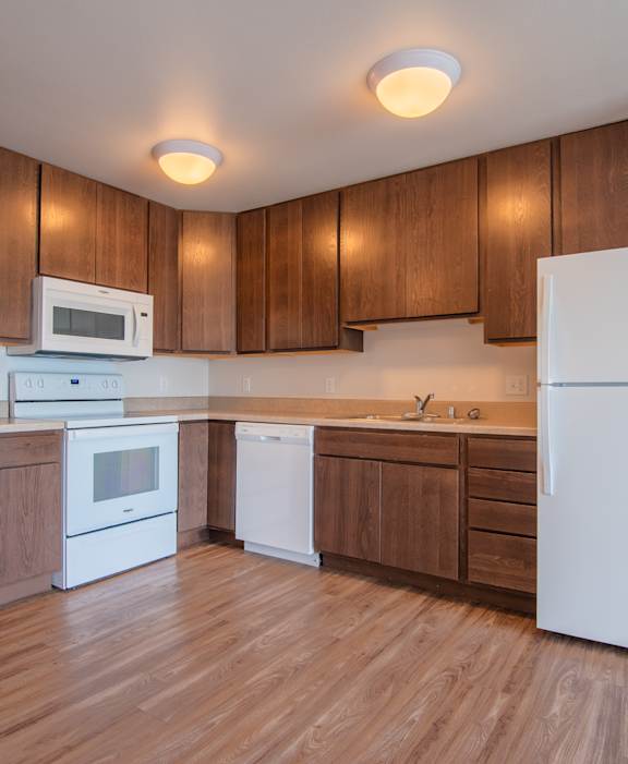 A kitchen with wooden cabinets and white appliances.