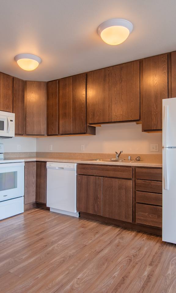A kitchen with wooden cabinets and white appliances.