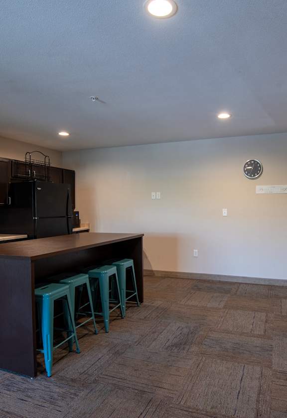 a kitchen and dining room with a bar with blue stools