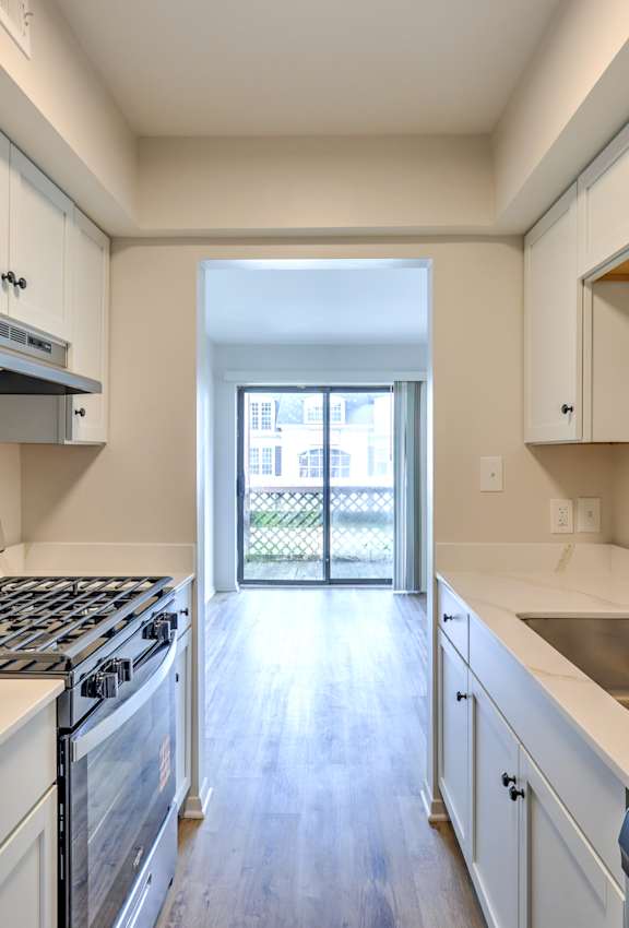 A kitchen with white cabinets and a stainless steel sink.